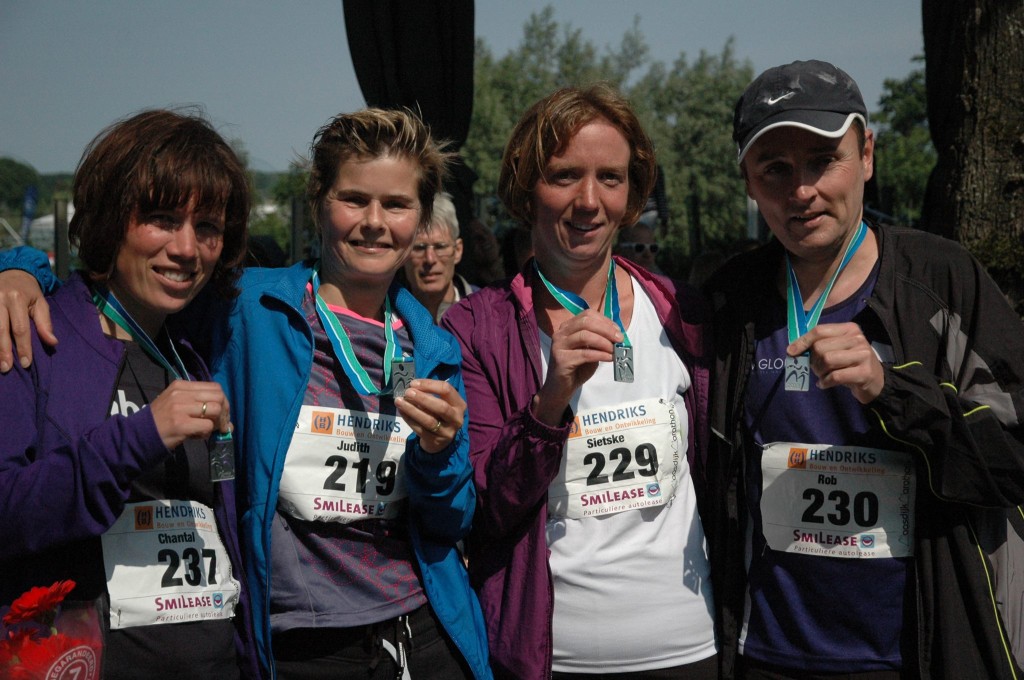 Een beetje moe maar voldaan tonen Chantal, Judith, Sietske en Rob hun verdiende marathonmedaille.